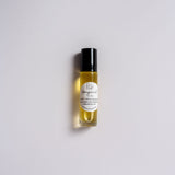 A roller bottle with a black lid and white label that says Lakota Made Bergamot Lip Oil. Ingredients are sunflower oil, argan oil, bergamot essential oil. The bottle is on a white background.