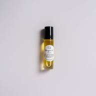 A roller bottle with a black lid and white label that says Lakota Made Bergamot Lip Oil. Ingredients are sunflower oil, argan oil, bergamot essential oil. The bottle is on a white background.