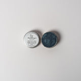 An open aluminum tin of midnight blue powder on a white background with a white label that says Lakota Made BHanchokanyan Dark Blue Eyeshadow Ingredients mica powder, kaolin clay powder, arrowroot powder.