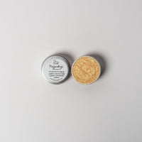 An open aluminum of sparkly gold powder tin on a white background with a white label that says Lakota Made Mazaskazi Gold Eyeshadow Ingredients mica powder, kaolin clay powder, arrowroot powder.