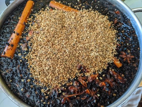 A pot filled with elderberries and dried flowers and herbs.